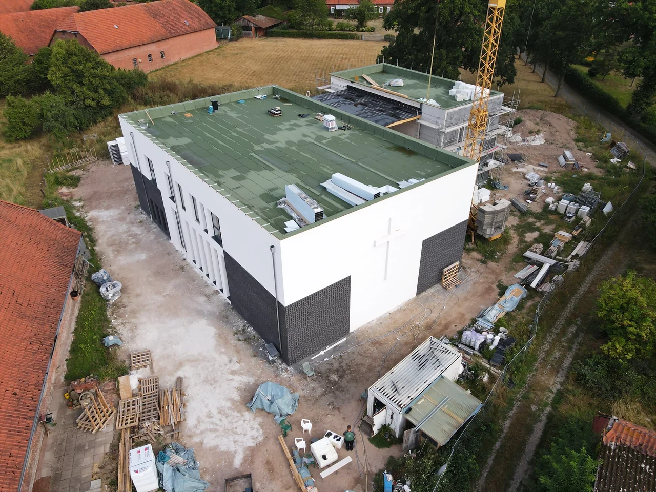 Blick über das fertige Dach und das Gelände rund um den Neubau